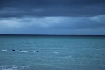 a group of rocks in the ocean under a cloudy sky at Hibernian Towers 505 in Strand