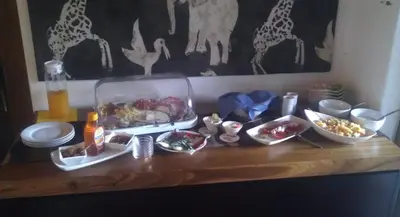 a table with a tray of food and bowls of food at Orange-Ville Lodge & Guesthouse in Stellenbosch