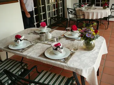 a table with plates of food and flowers on it at Orange-Ville Lodge & Guesthouse in Stellenbosch