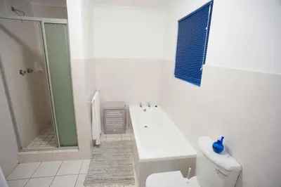 a bathroom with a tub and a toilet and a shower at 20 Cayman Beach, Gordon's Bay in Gordonʼs Bay