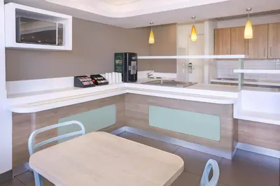 a kitchen with a counter and a chair in it at SUN1 MILNERTON in Cape Town