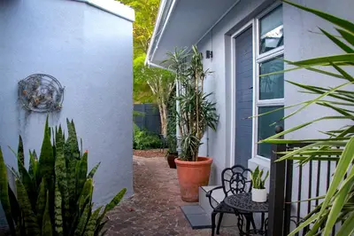 a patio with plants and a table and chairs at Olive tree private rooms in Stellenbosch- No Load Shedding in Stellenbosch