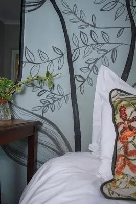 a bedroom with a bed with a tree mural on the wall at Olive tree private rooms in Stellenbosch- No Load Shedding in Stellenbosch
