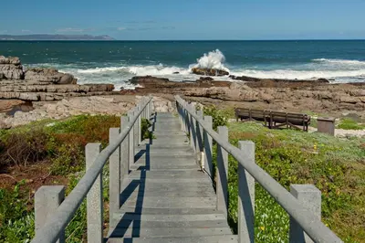 a staircase leading down to the beach with waves at 63 Whalerock Estate in Hermanus