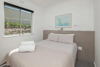 a small bedroom with a bed and a window at 63 Whalerock Estate in Hermanus