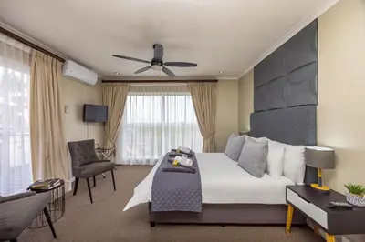 a hotel room with a bed and a chair at Plattekloof Premium Lodge in Plattekloof