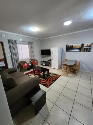 a living room with a couch and a table at 80 Kendal Self-Catering Guest House in Bellville