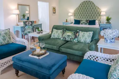 a living room with a green couch and a bed at Last Word Franschhoek in Franschhoek