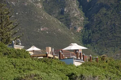 a building with umbrellas on top of a mountain at Kennedys Beach Villa in Hermanus