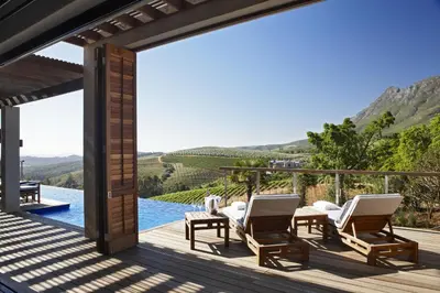 a view from the deck of a villa with chairs and a pool at Delaire Graff Lodges and Spa in Stellenbosch