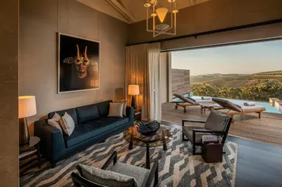 a living room with a blue couch and a table at Delaire Graff Lodges and Spa in Stellenbosch