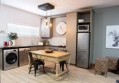 a kitchen with a table and chairs in a room at Avemore Vredehof No 3 full back up power in Stellenbosch