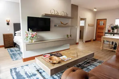 a living room with a flat screen tv on a wall at Avemore Vredehof No 3 full back up power in Stellenbosch