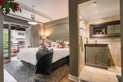 a bedroom with a large bed and a bathroom at Avemore Jan Cats No 2 full power back up in Stellenbosch