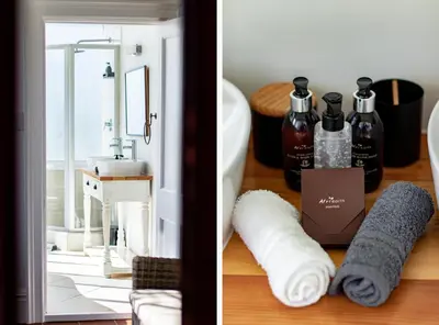 a bathroom with towels and a sink and a mirror at Carmichael House Boutique Hotel in Cape Town