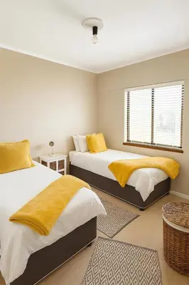 a bedroom with two beds and a window at Luxurious Beach Front in Strand