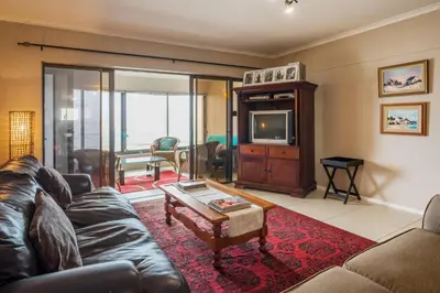 a living room with a couch and a tv at Luxurious Beach Front in Strand