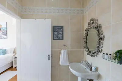 a bathroom with a sink and a mirror at Atlantic Beach Villa in Cape Town