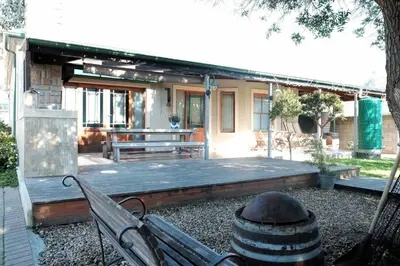 a wooden deck with a bench in front of a house at The Yard in Gordonʼs Bay