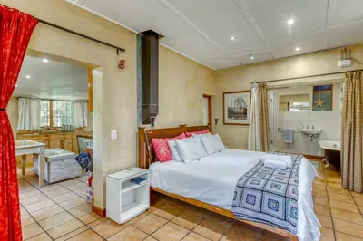 a bedroom with a bed and a bathroom at The Yard in Gordonʼs Bay