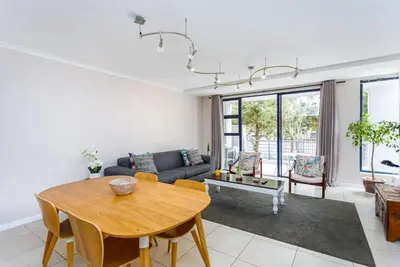 a living room with a table and a couch at Waterstone A103 by CTHA in Cape Town