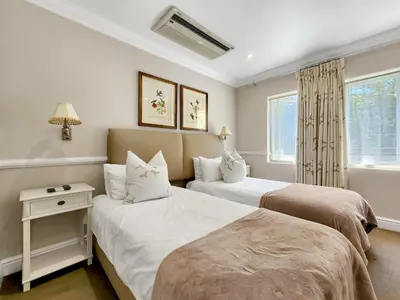 a bedroom with two beds and a window at Roodenburg House in Cape Town