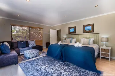 a bedroom with a large bed and a couch at Atlantic Bay Lodge in Cape Town