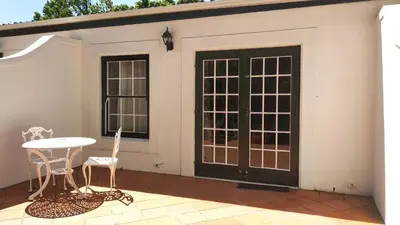 a patio with doors and a table and chairs at Le Manoir de Brendel in Franschhoek