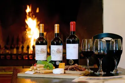 three bottles of wine sitting on a table with wine glasses at Zorgvliet Wines Country Lodge in Stellenbosch