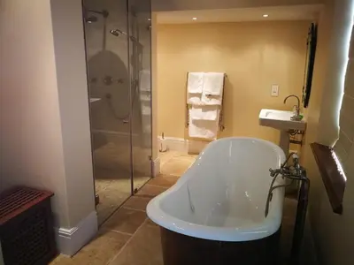 a bathroom with a shower and a tub and a sink at Gemoedsrus Farm in Stellenbosch