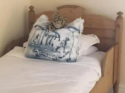 a teddy bear sitting on top of a bed with pillows at Gemoedsrus Farm in Stellenbosch