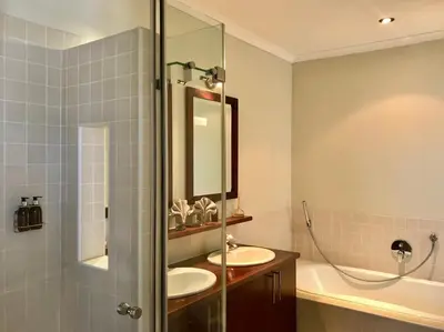 a bathroom with a sink and a shower at Manor on the Bay in Gordonʼs Bay