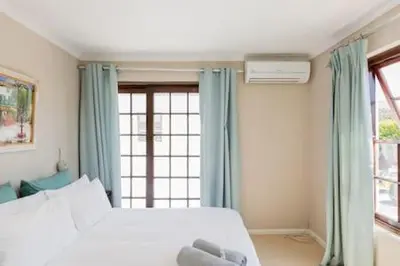 a bedroom with a bed with a teddy bear on it at Nansen Place in Cape Town