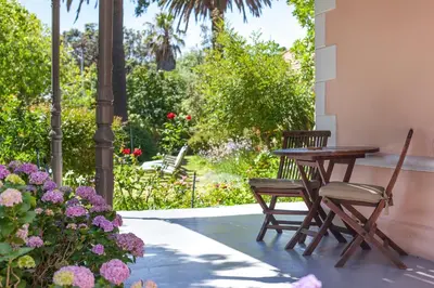 a patio with a table and chairs and flowers at Medindi Manor in Cape Town