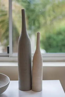 two white vases sitting on a table next to a window at Morgen Guesthouse Somerset West in Somerset West