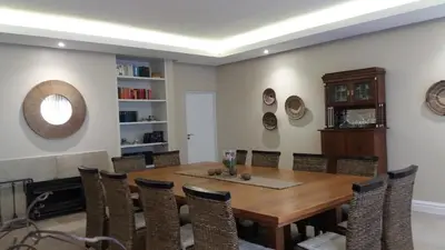 a dining room with a wooden table and chairs at La Roche Guest House in Cape Town