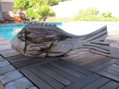a statue of a bird sitting on a deck next to a pool at La Roche Guest House in Cape Town
