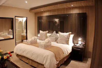 a bedroom with a large bed and a large mirror at Keret Accommodation in Bellville