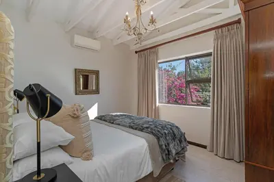 a bedroom with a bed and a window at Cape Goodness in Bellville