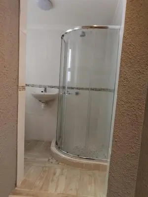 a glass shower in a bathroom with a sink at Cape Pine Guest House in Kuilsrivier
