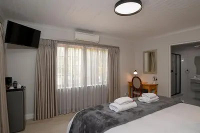 a bedroom with a bed with two towels on it at Dark Chocolate Guest House in Durbanville