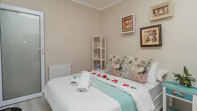 a bedroom with a bed with flowers on it at Sea Breeze Guest House in Bloubergstrand