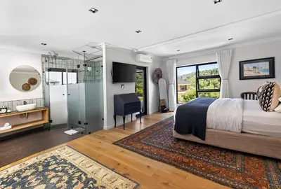 a bedroom with a king sized bed and a desk at The Whale's Tale Guesthouse in Hermanus