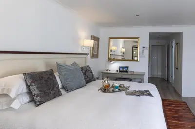 a bedroom with a white bed with a tray on it at Cape Pillars Boutique Hotel in Durbanville
