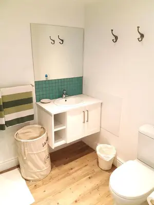 a bathroom with a sink and a toilet and a mirror at Bayview Bliss in Hermanus