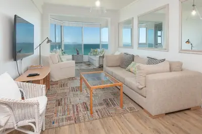 a living room with a couch and chairs and a table at Bayview Bliss in Hermanus