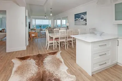 a kitchen and living room with a table and chairs at Bayview Bliss in Hermanus