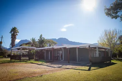 a house with a porch and mountains in the background at Damas Guest Farm in Worcester