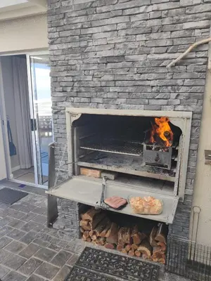 a stone fireplace with a plate of food in it at House 10-on-Sea in Hermanus