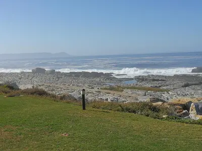 a pole on the side of a hill overlooking the ocean at House 10-on-Sea in Hermanus
